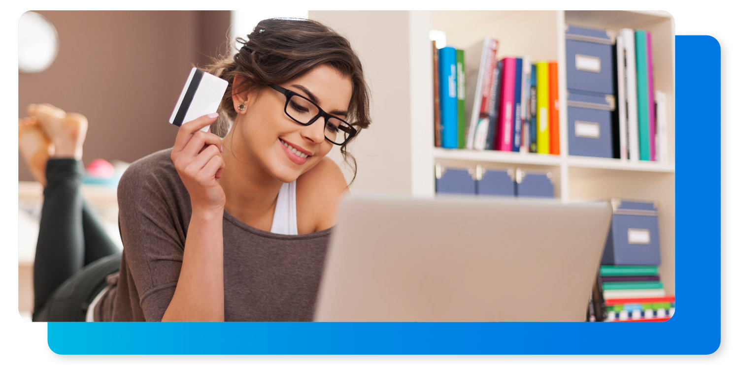 Mujer en una laptop con tarjeta de crédito lista para comprar alineadores transparente.
